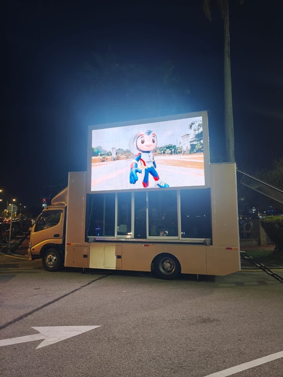 LED truck screen lit at full brightness in an open car park at night